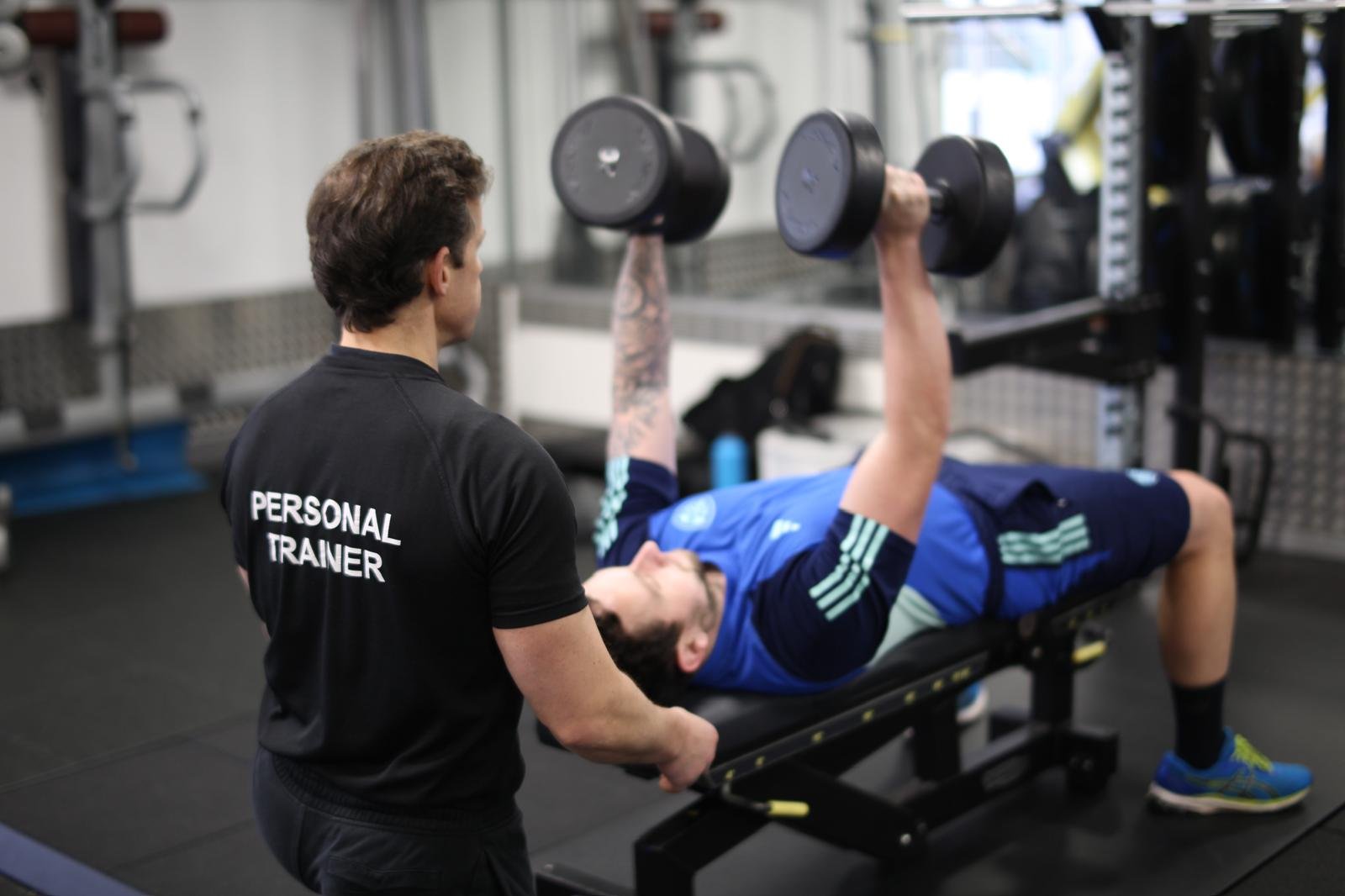 Joe Petherwick coaching a client during a dumbbell chest press