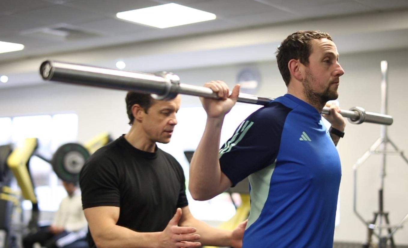 Joe Petherwick coaching a client through a barbell squat
